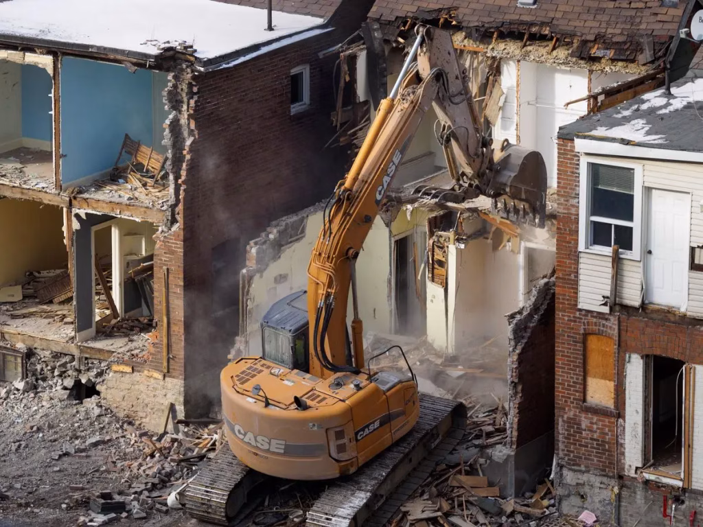 Excavator tearing down a building during a demolition job